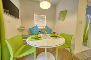 Paget ParishBeach Walk Studio的一间设有白色桌子和绿色椅子的用餐室