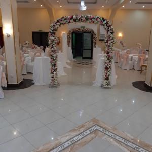 阿尔及尔Numidien Hotel的宴会厅设有白色桌子和花卉拱门