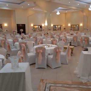 阿尔及尔Numidien Hotel的宴会厅配有白色的桌椅和弓形