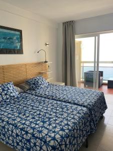 阿尔姆尼卡Apartamentos Chinasolymar的一间卧室配有一张带蓝色棉被的床