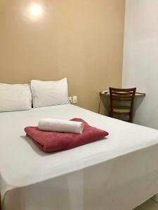 里奥韦尔迪Acapu Hotel的一张白色的床,上面有红色的毛巾