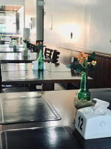 里奥韦尔迪Acapu Hotel的一排绿玻璃花瓶里花的桌子