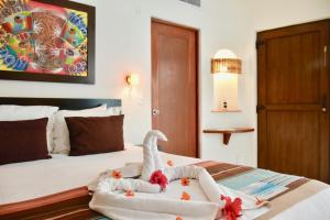 普拉亚卡门棕榈滩海滩公寓式酒店的酒店客房,配有一张床铺,上面有毛巾动物