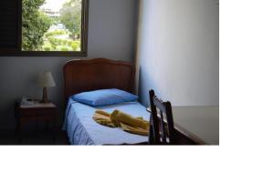 贝洛奥里藏特索伦托酒店的一间卧室配有一张带蓝色枕头和椅子的床