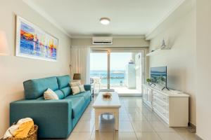 莫甘海滩Amarre Ocean的客厅配有蓝色沙发,享有海景