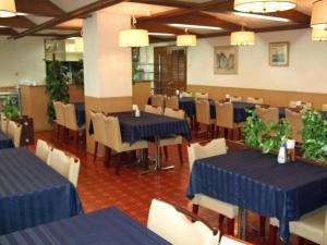 丰中A.P酒店的用餐室配有蓝色桌子和白色椅子