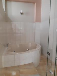 廷戈玛丽亚Hotel El Ensueño的带浴缸的浴室和玻璃门