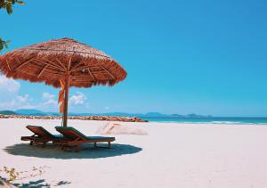 宁普Wild Beach Boutique Resort的一个带两把椅子和一把遮阳伞的海滩
