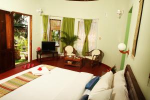 可瓦兰索玛帕姆苏酒店的一间卧室设有一张床和一间客厅。