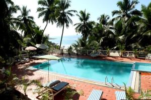 可瓦兰索玛帕姆苏酒店的一座棕榈树和海洋游泳池