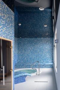 齐莱涅克Przystanek Alaska的蓝色的浴室设有蓝色瓷砖和浴缸