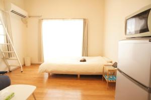 福冈Plusone Fujisaki的一间卧室设有一张床和一个大窗户