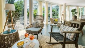 梅拉诺Hotel Villa Laurus的客厅配有椅子和桌子
