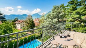 梅拉诺Hotel Villa Laurus的一个带桌椅的阳台和一个游泳池