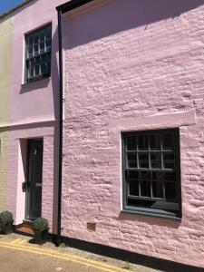 基督城Boutique Townhouse in Christchurch Dorset的粉红色的建筑,设有2个窗户