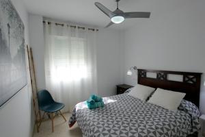 桑卢卡尔-德巴拉梅达Sanlúcar Apart Airen!!的一间卧室配有一张床和一张蓝色椅子