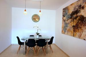 桑卢卡尔-德巴拉梅达Sanlúcar Apart Airen!!的一间设有玻璃桌和椅子的用餐室