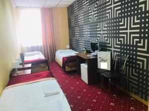 喀山Davidov Inn的客房设有两张床和一张带电脑的书桌