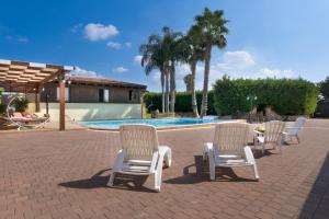 玛丽娜迪曼卡维萨Luxury Pool Chalet的游泳池旁一排白色椅子