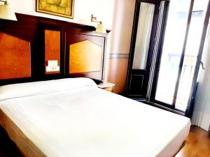 萨拉曼卡Hosteria Sara by gaiarooms的一间卧室设有两张白色的床和窗户