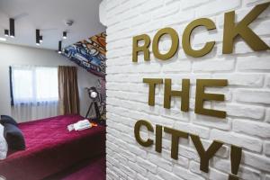 克卢日-纳波卡洛尔和洛拉酒店的一间设有砖墙的卧室,并有读取城市岩石的标志