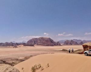 El QuweiraMalakoRum的两个人站在沙漠里,坐了一辆汽车