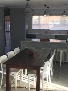 布隆方丹Tortilla no 3的厨房里配有一张木桌和白色椅子