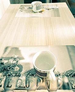 维罗纳LA CASA DI CHICCO E GINNY的坐在桌子上盘子上的咖啡杯