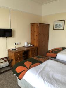 莱顿巴泽德The Hunt Lodge的酒店客房设有两张床、一张书桌和一个水槽