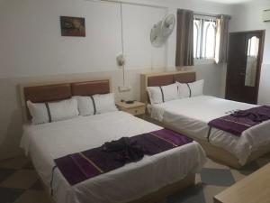 西哈努克Don Bosco Guesthouse的一间酒店客房,房间内设有两张床