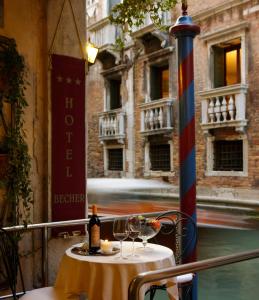 威尼斯贝歇尔酒店的一张桌子,上面放着眼镜和一瓶葡萄酒