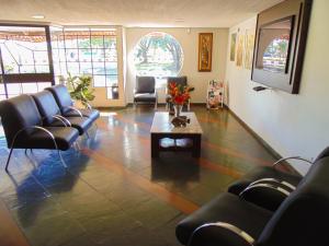 伊瓜苏达曼酒店的一间设有皮椅和茶几的等候室