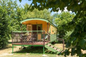拉加西利拉维斯自然露营地的黄色和绿色的小房子,设有门廊