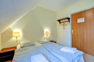 岑讷Abild Kro & Hotel的一间卧室配有一张带蓝色床单和枕头的床。