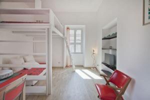 罗马Colosseum relax family apartament的带两张双层床和红色椅子的房间