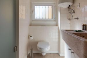 里斯本Typical and Brand New T.M. Flat的一间带卫生间、水槽和窗户的浴室