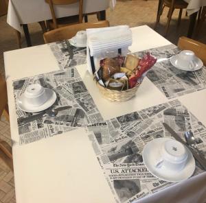 奥梅尼亚Ostello di Germagno的一张桌子,上面放着一篮子的食物和报纸