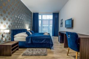 普雷绍夫Hotel Black Horse的蓝色的卧室配有蓝色的床和一张书桌