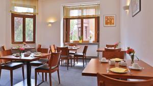 海德堡鳄鱼餐厅酒店的餐厅设有木桌、椅子和窗户。