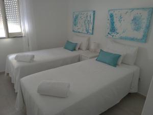 奥良Casa da avó Lu的白色客房的两张床,拥有蓝色调