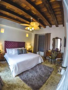 卡塔赫纳Hotel Casa la Tablada的卧室配有白色的床和吊扇