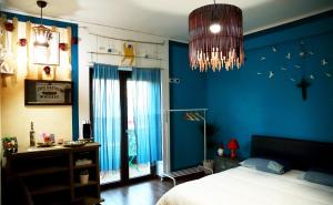 切尔科拉Fabio Room Cercola的一间拥有蓝色墙壁的卧室、一张床和一个吊灯