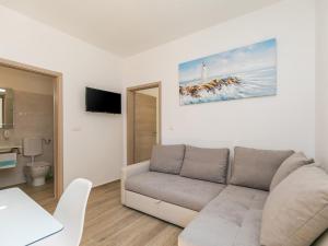 维斯尼安Apartment Stefano - free wine&spirit tasting的带沙发和电视的白色客厅