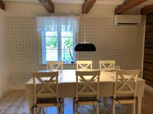 EdsbroNedanby | Cottage | Idyllic location | Porch | Grill的一间带桌子和四把椅子的用餐室