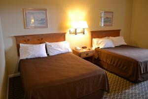 半月湾The Miramar Inn & Suites的酒店客房带两张床和电话