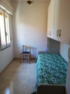 弗卢米尼马焦雷Casa vacanza的一间卧室配有一张床和一把椅子