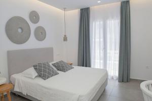 纳克索乔拉Casabella的白色的卧室设有床和窗户
