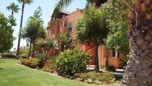 卡萨雷斯Casares del Sol Penthouse的一座橘色的建筑,在院子里种有树木和植物