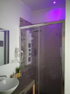 普雷西切B&B Suites Via del Mare的一间带玻璃淋浴和水槽的浴室