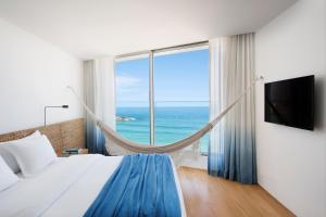 里约热内卢阿普多酒店的一间卧室配有一张床,享有海景